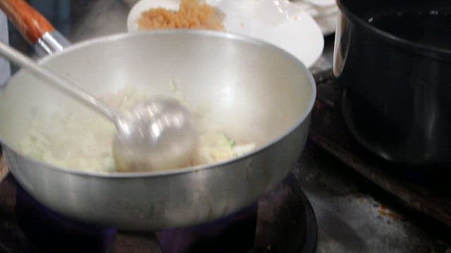 팬에서 볶아지는 다진 양파와 애호박