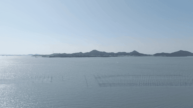 Calm sea with mountains visible in distance.