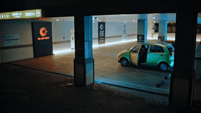 A person getting into a car in a parking garage