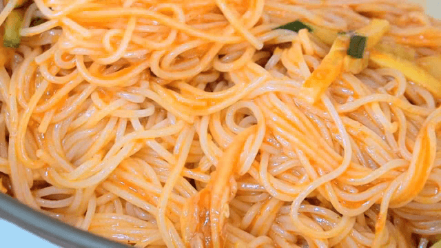 Mixing Korean spicy noodles in a bowl