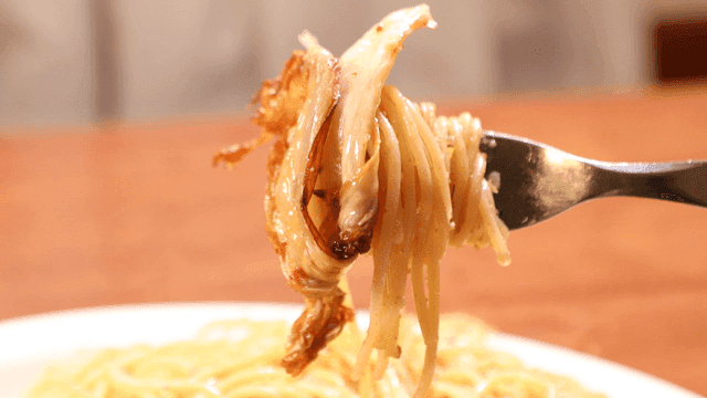 Fork picking up pasta served with roasted aged kimchi