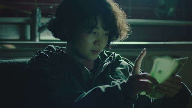 어두운 방에서 돈을 세고 있는 여자