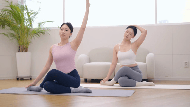 Yoga instructor guiding a student indoors