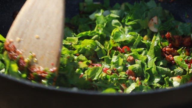 팬에서 다진 채소와 고기를 볶는 장면