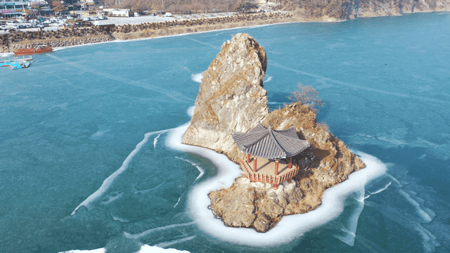 Pavilion on rocky island in frozen river