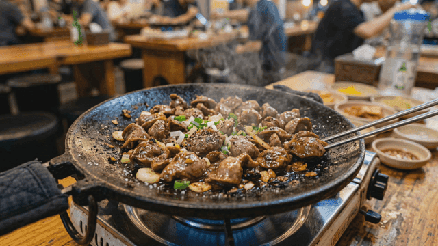 Stir-fried chicken gizzards on gas burner grill