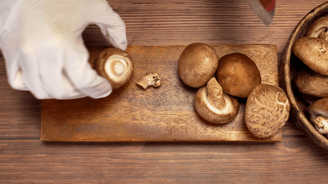 나무 도마 위에서 버섯 자르기