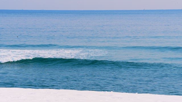 Calm ocean waves meeting a snowy beach