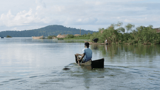 Man rowing a boat on a calm river