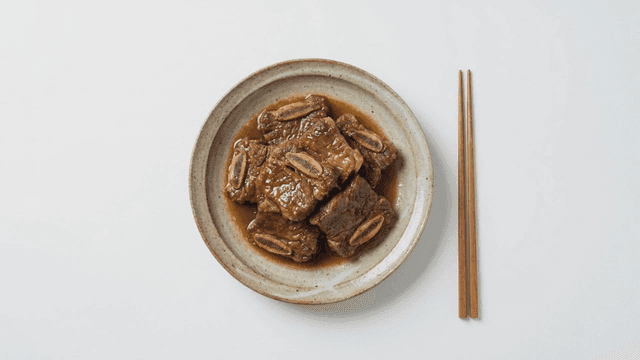 Chopsticks and plate of seasoned braised short ribs