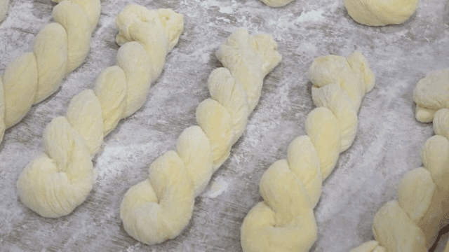 밀가루를 뿌린 표면 위의 꼬인 반죽