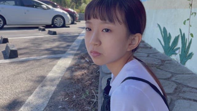 한낮에 화단 앞에 앉아 장난을 치며 웃는 소녀