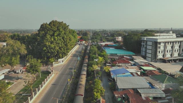 주변의 녹지와 건물이 있는 주거 지역을 지나는 기차
