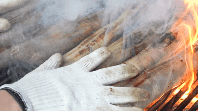 Grilling makchang sundae over flaming smoky grill