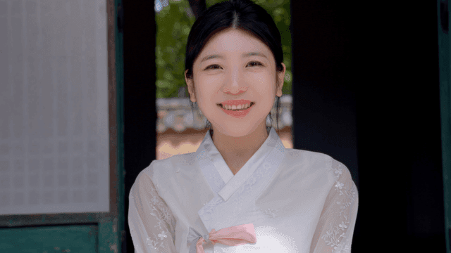 Woman in hanbok smiling outdoors