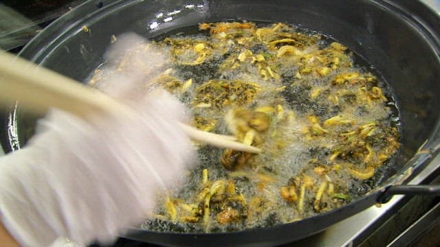 Sweet potato fritters frying in hot oil