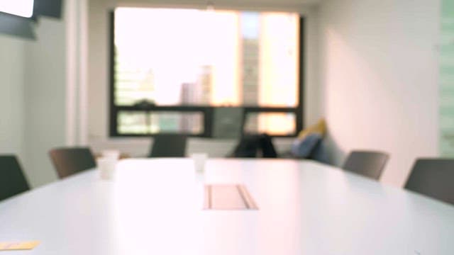 Two people standing and shaking hands in an office