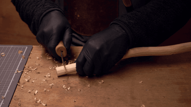 Person carving wood with precision