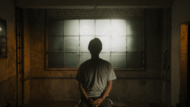 A person sitting in a dimly lit room