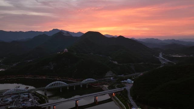 Twilight glow over bridge and mountain ridge