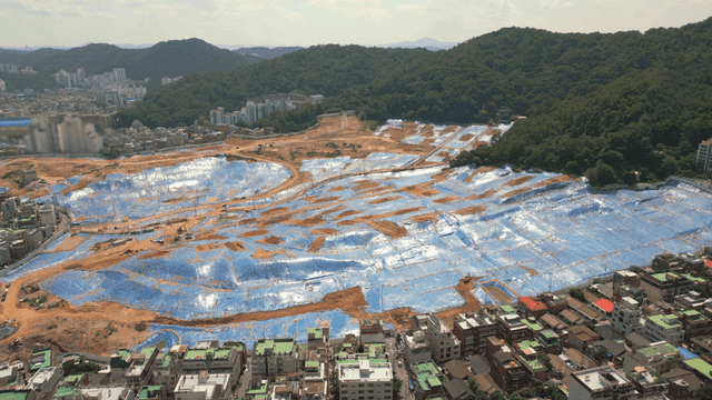Large construction site with blue tarps