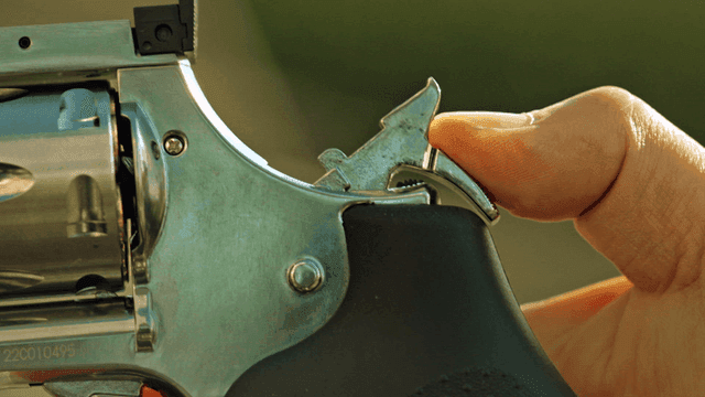 방아쇠에 손가락을 올린 총의 근접 촬영