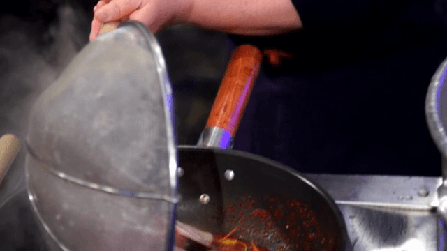 Placing blanched squid into spicy sauce