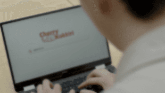 책상에서 노트북으로 작업하는 사람