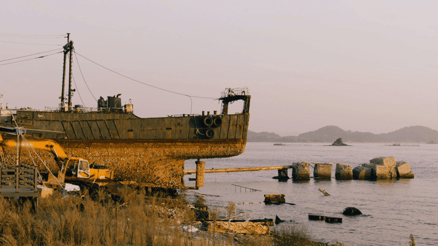 Rusty ship by the shore with distant islands