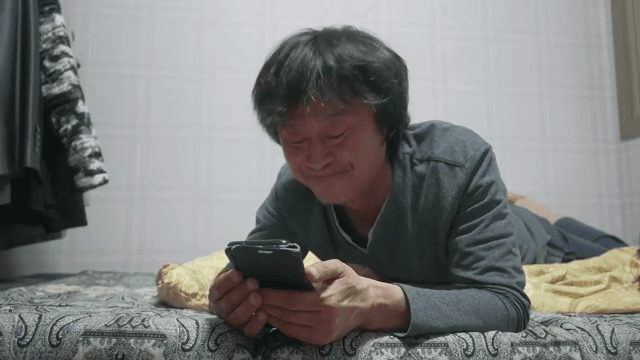 Man lying in bed talking on smartphone