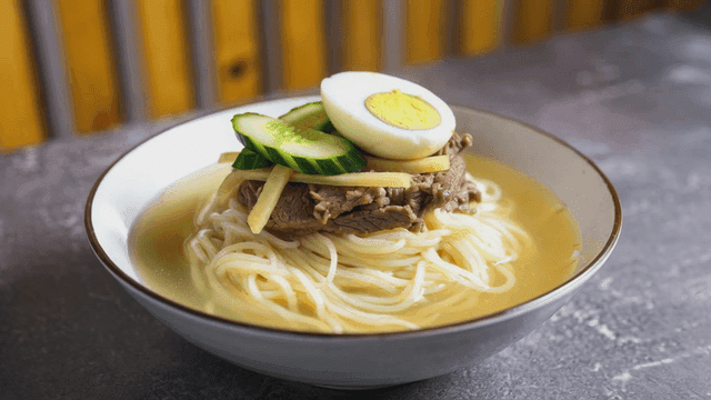 Bowl of cold noodles topped with beef and egg