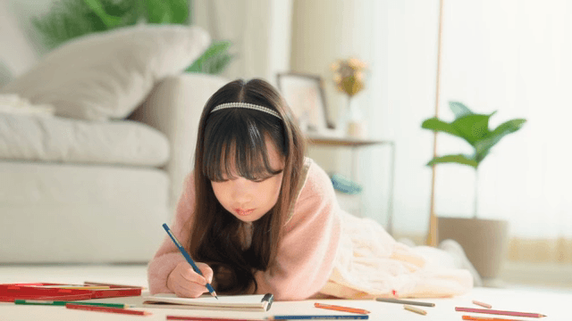 Young girl drawing with colored pencils
