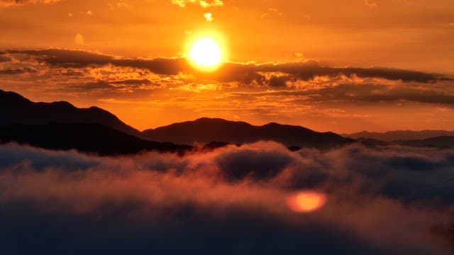 구름 위로 산을 비추는 일몰
