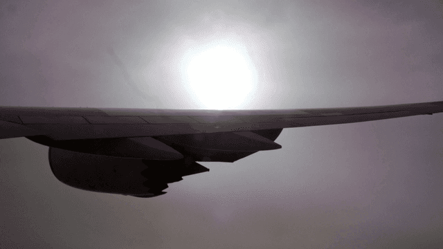 Airplane wing against a bright sun