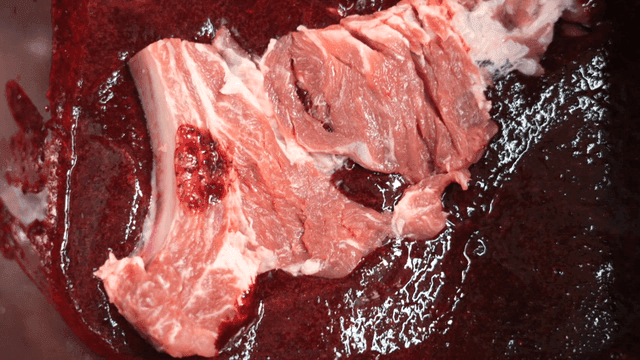 Raw meat being marinated in sauce