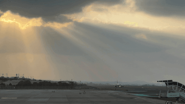 Airplane on runway with sunbeams