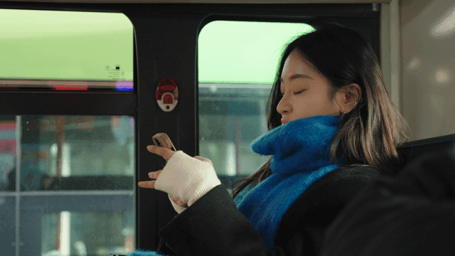 Profile of a woman using a smartphone on a bus