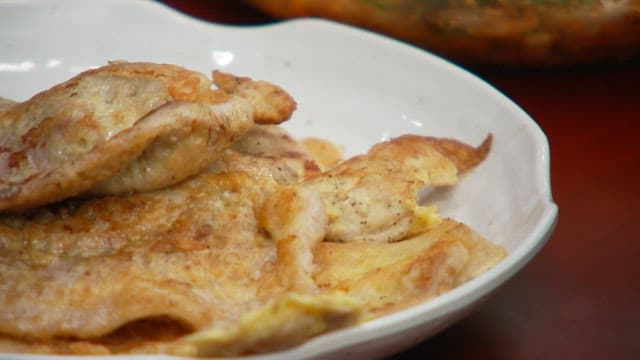 식탁 위 흰 접시에 담긴 노릇노릇한 육전