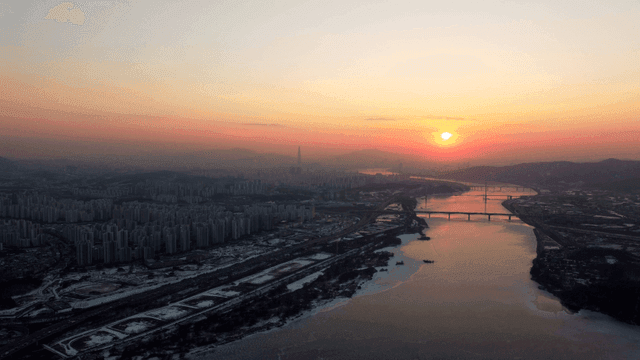 Sunset over a city with a river view