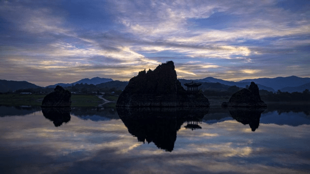 새벽에 바위섬과 정자가 있는 고요한 호수