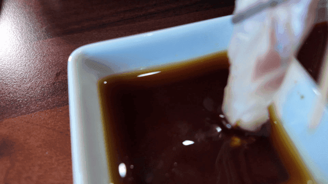 Fresh sashimi being dipped in soy sauce