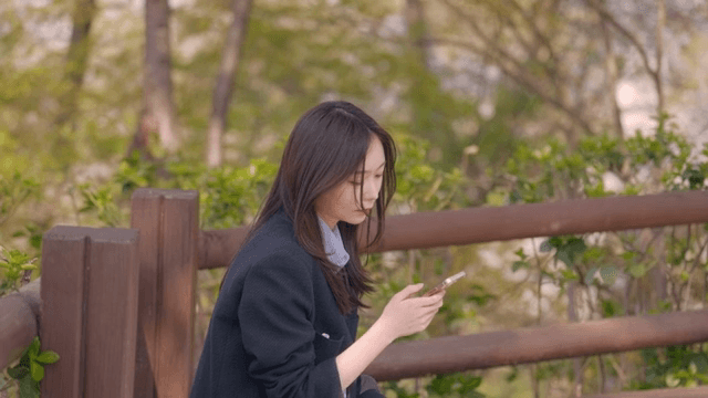 Woman sitting on park bench waiting for someone