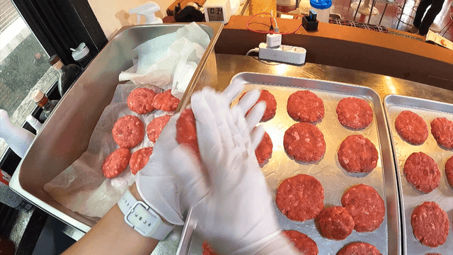 장갑 낀 손으로 고기 패티를 만드는 모습
