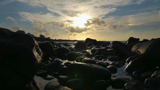 구름 사이로 비치는 햇빛과 바위 해안