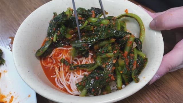 Preparing bibim noodle with gochujang and vegetables