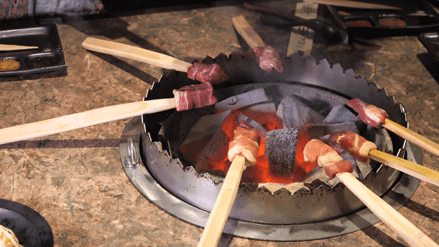 돌화로에 둘러 익혀지는 꼬치 재료들