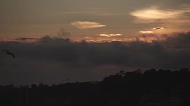 구름의 흐름과 실루엣이 보이는 일몰의 하늘