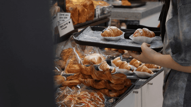 Person selecting pastries in a bakery