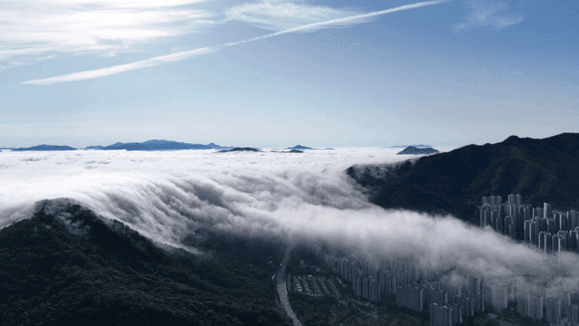 Clouds rolling over mountains and cityscape