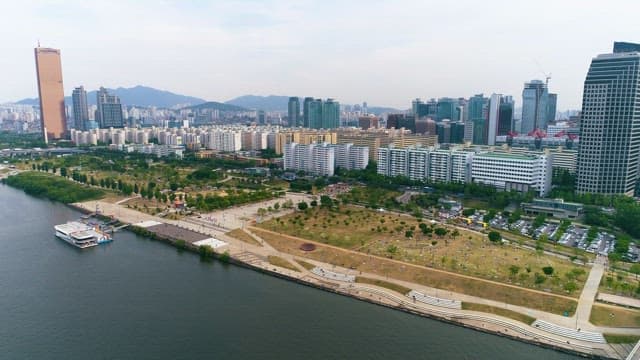 Calm Riverside Park and Dense Cityscape